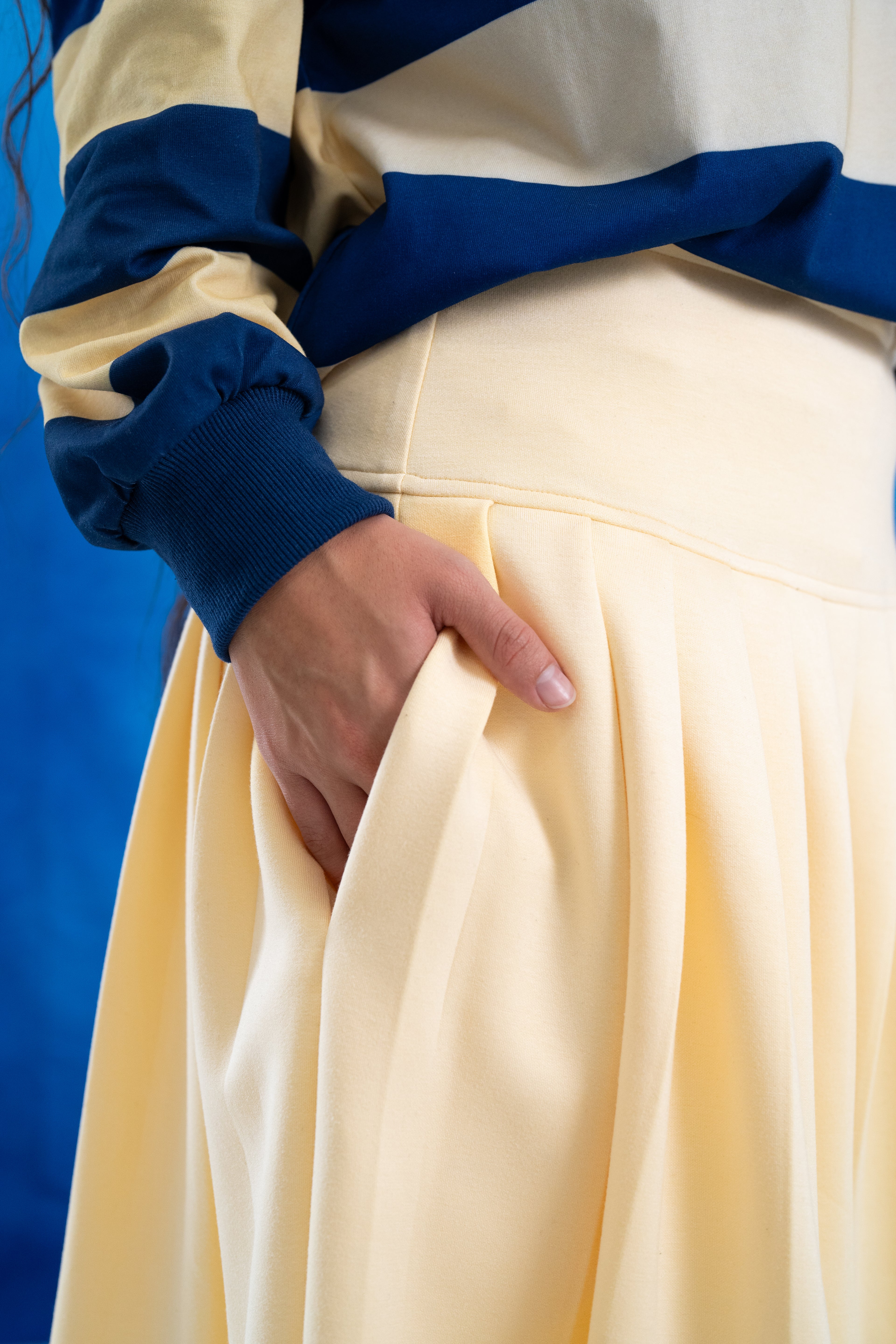 Person wearing a blue and yellow outfit with a focus on the skirt. 