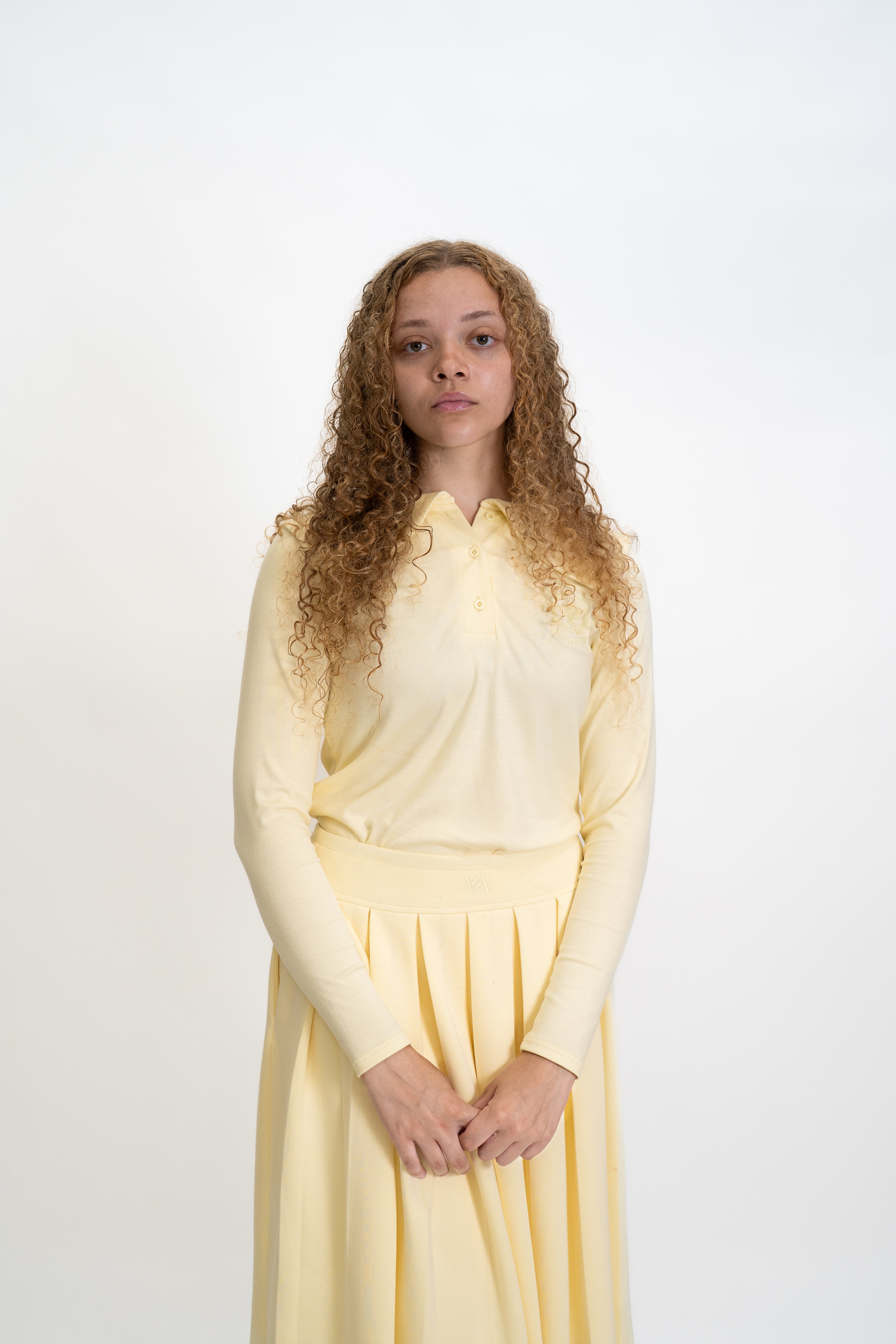 Woman wearing a light yellow dress against a white background