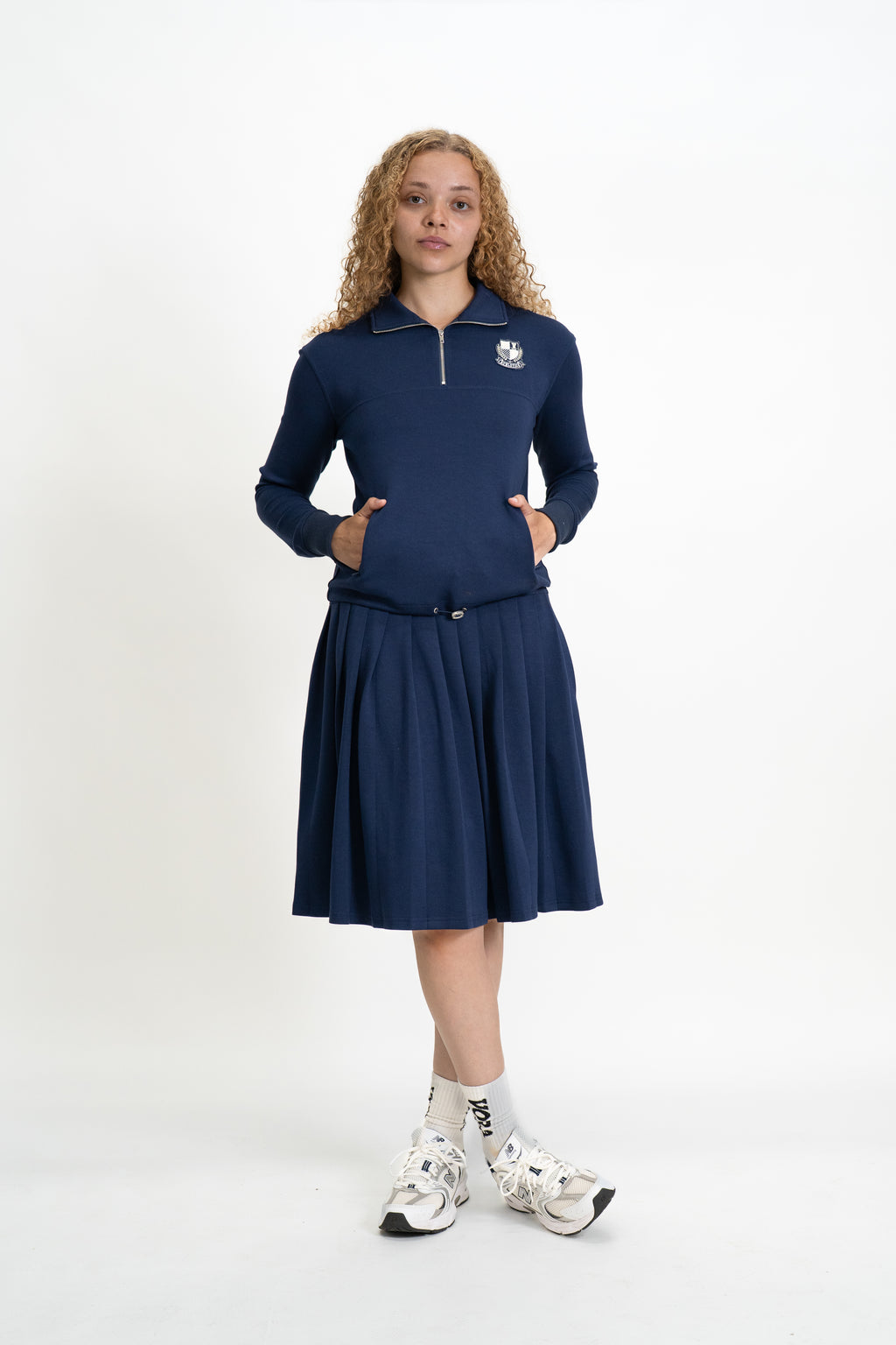 Woman wearing a navy blue dress with a logo on a white background